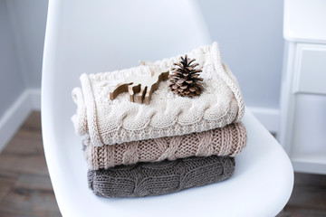 A stack of knitted sweaters on chair in Interior of the living room