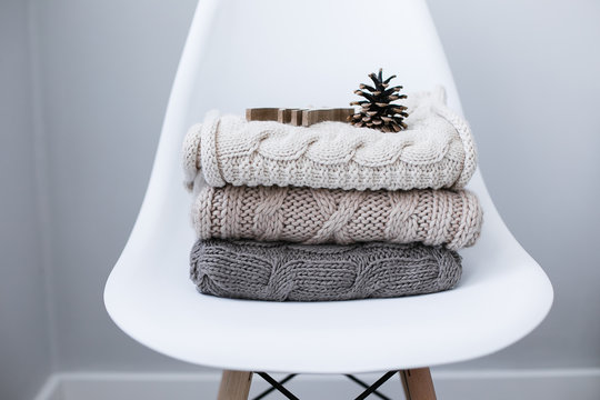 A stack of knitted sweaters on chair in Interior of the living room