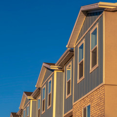 Square frame Townhomes on a neighborhood with vibrant blue sky background on a sunny day