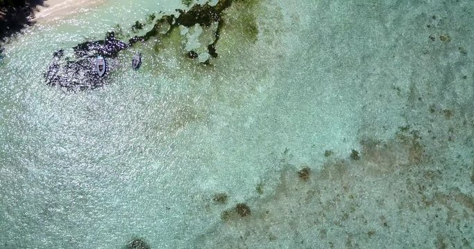 Beautiful seabed seen from above with white pebbles and algae underwater on tropical bay of island in Fiji
