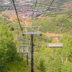 Square Chairlifts overlooking trails and buildings at a ski resort during off season