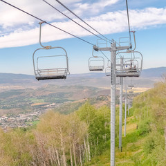 Square frame Park City during summer with chairlifts overlooking trees and mountain