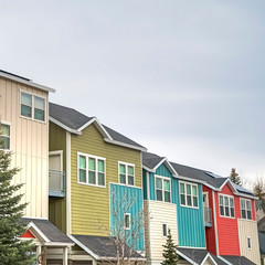 Square frame Townhouses with colorful exterior walls with cloudy sky background in winter