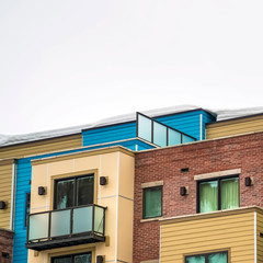 Square Exterior of townhouses in Park City Utah with balconies and snowy roof in winter