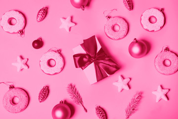 paper pink background with Christmas decoration balls, donuts, gift and stars.   flat lay, top view. Christmas card conception. Toned into pink color