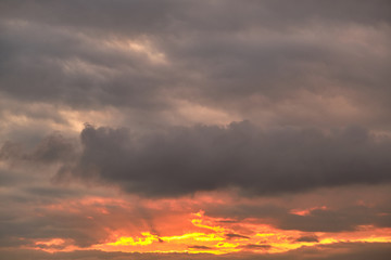 Golden sunrise on a background of gray clouds