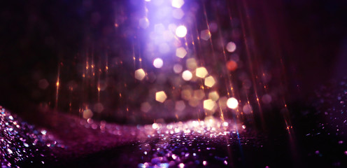 abstract glitter pink, purple, black and gold lights background. de-focused