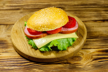 Fresh delicious homemade cheeseburger on wooden table
