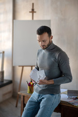 Interior designer wearing jeans standing near table