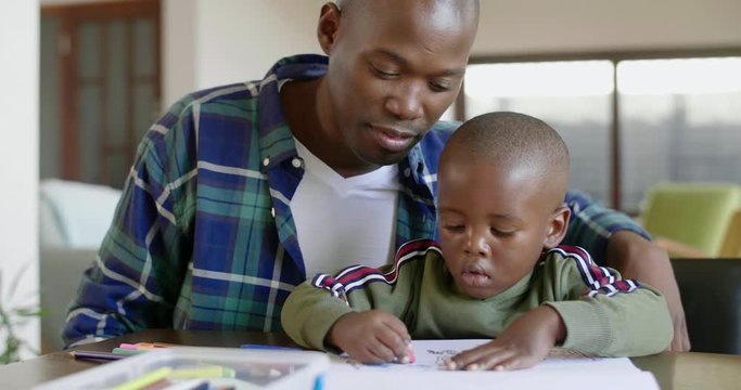 Black african family together at home, dad watching kid child boy son drawing pictures