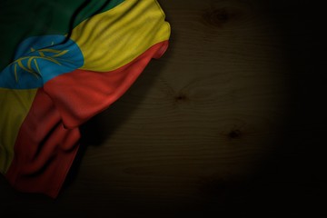 pretty dark picture of Ethiopia flag with large folds on dark wood with empty place for content - any celebration flag 3d illustration..