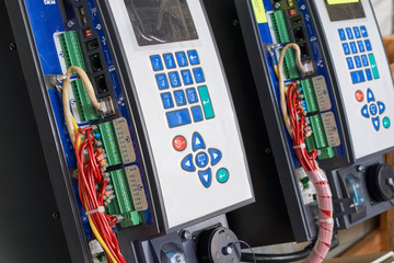 Controllers for remote control with buttons for direct control and settings are arranged in a row. Electrical wires and network cable are connected to the controllers. Devices have a screen.