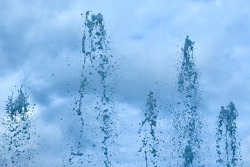 Close up view of water spray in fountain in blue color - background