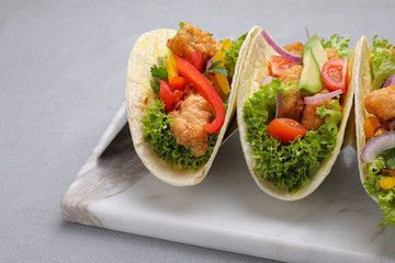 Delicious fish tacos served on grey table, closeup