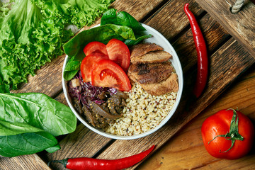 Vegetarian bowl with quinoa and bulgur, with soy meat and tomatoes on a wooden tray in a composition with vegetables. Top view food flat lay. Healthy balanced food
