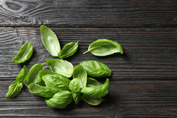 Fresh green basil on black wooden table, top view