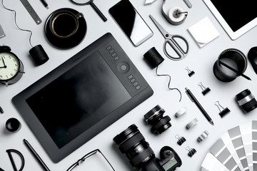 Flat lay composition with graphic drawing tablet and different office items on light background....