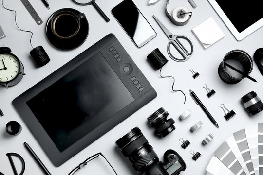 Flat lay composition with graphic drawing tablet and different office items on light background. Designer's workplace