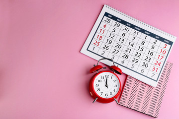 Fototapeta na wymiar Calender, notebook and alarm clock on pink background, flat lay. Space for text