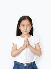Portrait smiling beautiful little asian girl praying isolated over white background. Sawasdee is...