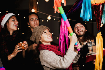 breaking a piñata celebrating a Mexican Posada in Christmas Mexico