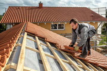 Roofer at work, installing clay roof tiles, Germany - obrazy, fototapety, plakaty