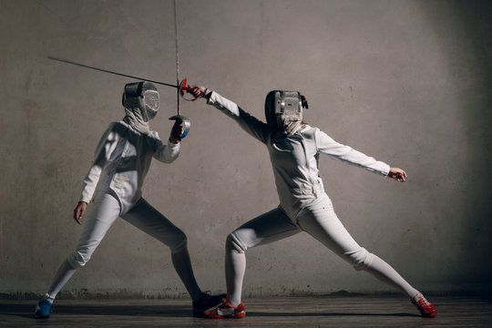 Fencer  with fencing sword. Fencers duel concept.