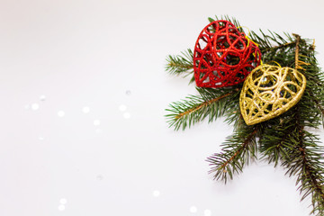 Green spruce branch with glitter decorations in the corner close up on white background