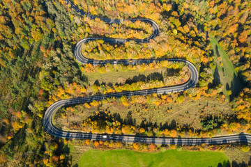 Beautiful aerial landscape of mountain forest road. Aerial view of curvy road in beautiful autumn forest