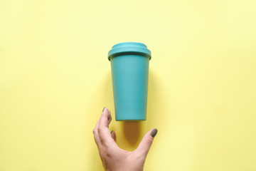 A woman's hand reaches for her coffee mug