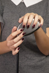 Girl with manicured fingernails and a golf club on a white background.
