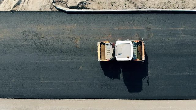 Asphalt spreader in motion in a top view