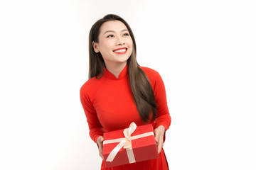 Beautiful girl in Vietnamese traditional dress is smiling and holding a box with a gift
