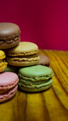 Colored macarons isolated on wooden dish, typical French dish