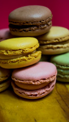Colored macarons isolated on wooden dish, typical French dish