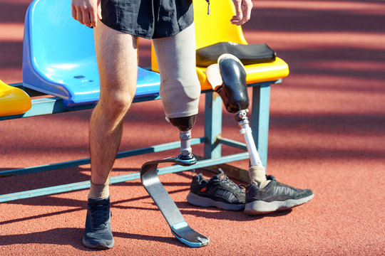 Sportsman with prosthetic leg standing near seats and getting ready for a run