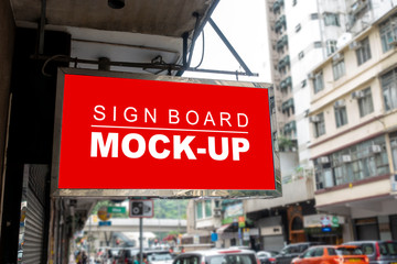 Obraz premium Mock up signboard hanging over street at front of shop