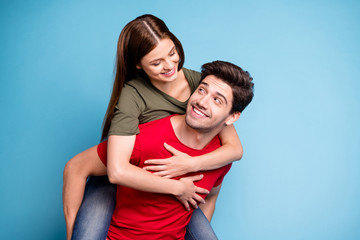 Portrait of positive romantic two dreamy couple man hug his wife spouse piggy-back wear casual style outfit isolated over blue color background