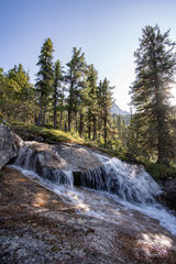 River flowing through autumn colorful forest. Beautiful fall river with rocks and trees