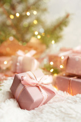 Christmas.Holiday Gifts in boxes in pink packaging near fir branches with copy space on a light background, Christmas and New Year background.
