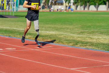 Amputee athlete running on a stadium track.