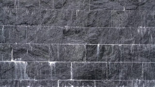 waterfall on black stone brick wall background
