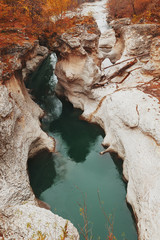 Gorge with a mountain river with a vibrant turquoise water between the rocks.