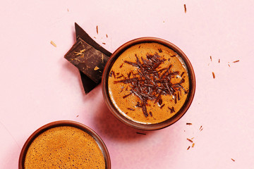 Two cups of hot chocolate or cocoa drink on the pink table