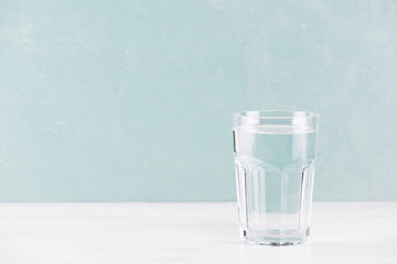 Blue background with glass of pure water on the table - 302156261