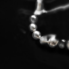 Coastal jewellery fashion, pearl necklace under black water background, glamour style present and...