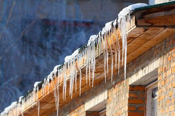 icicles which are hanging down from a roof - obrazy, fototapety, plakaty