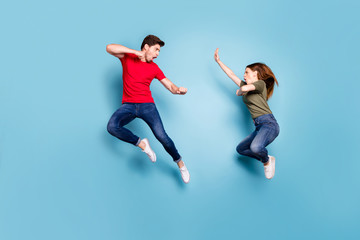 Fototapeta na wymiar Full size photo of crazy mad two people married man woman jump train kickboxing exercise kick decide who is best wear green red t-shirt denim jeans isolaed over blue color background