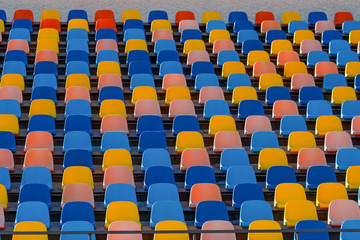 Fototapeta premium Blue and orange stadium plastic seats. Colorful texture, rows of an arena.