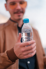 young guy holding a water bottle in his hands. healthy lifestyle concept. selective focus.